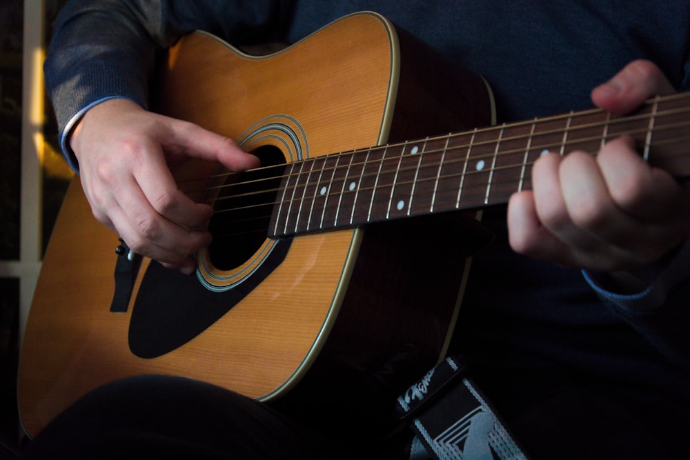 person playing acoustic guitar