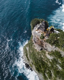A scenic view of Uluwatu Temple perched on a cliff overlooking the ocean.
