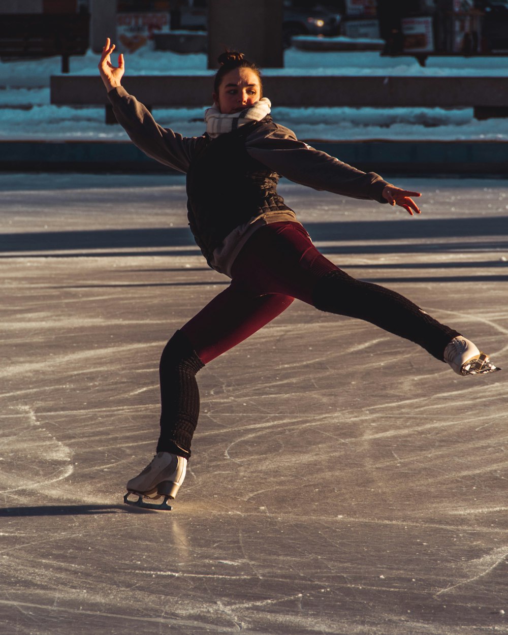 woman in red pants and coat using ice skates on skating rink