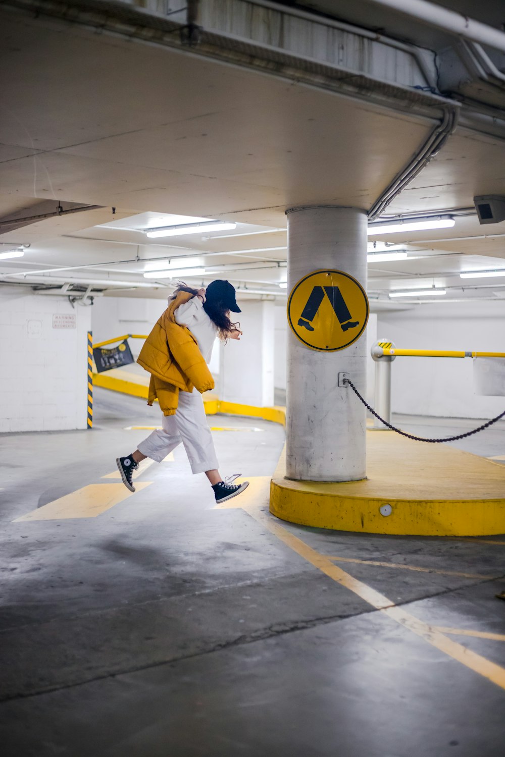 person wearing white jacket and pants jumping on parking lot