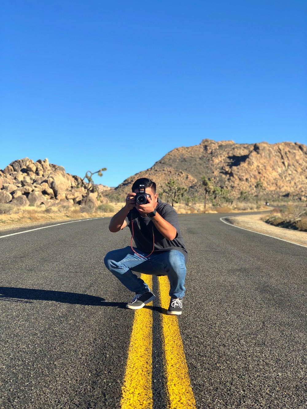 man sitting in road taking picture