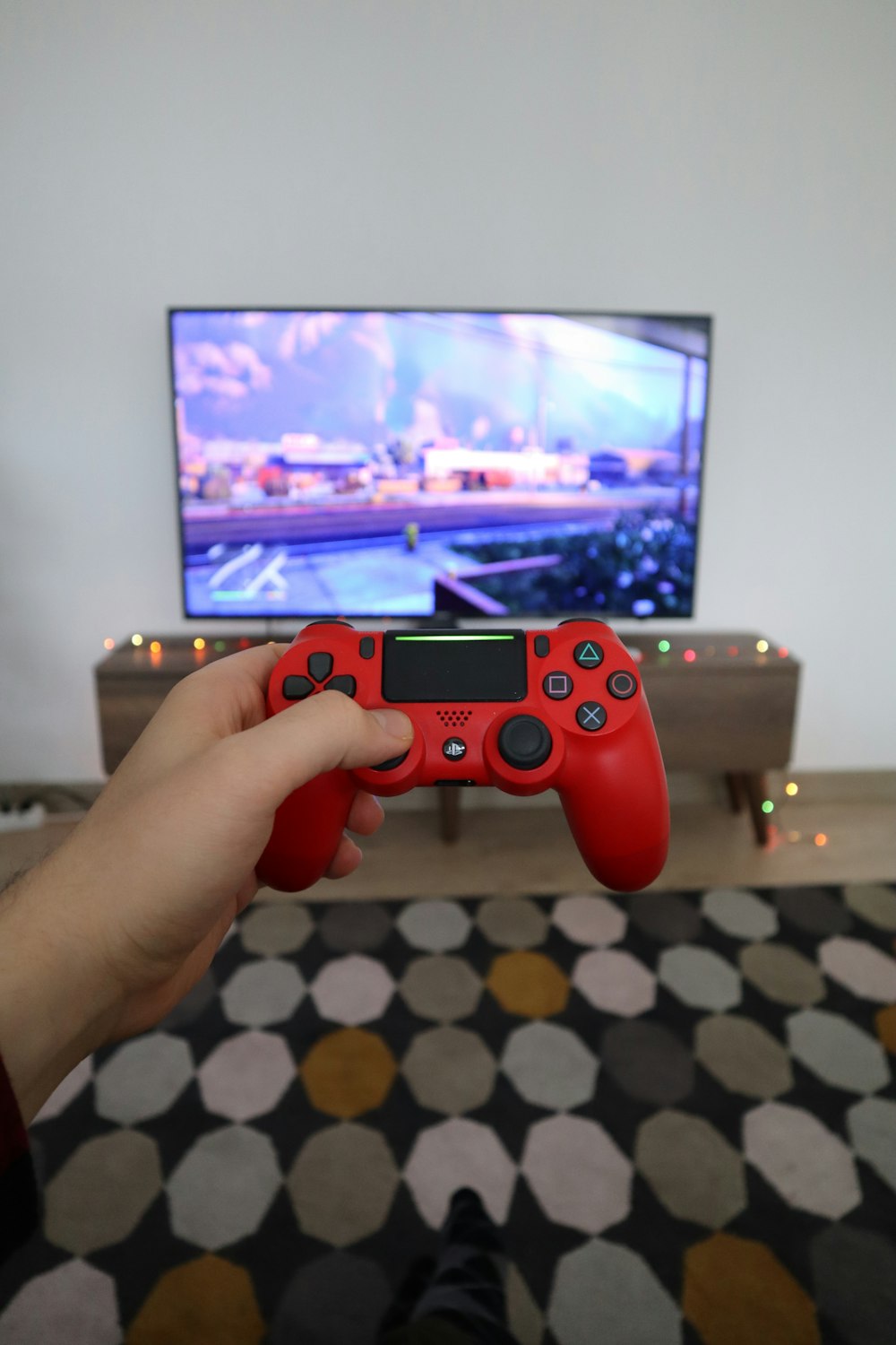 Person mit rotem PS4-Controller