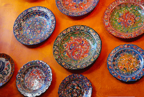 Close-up of a hand-painted ceramic plate with bright, cheerful patterns