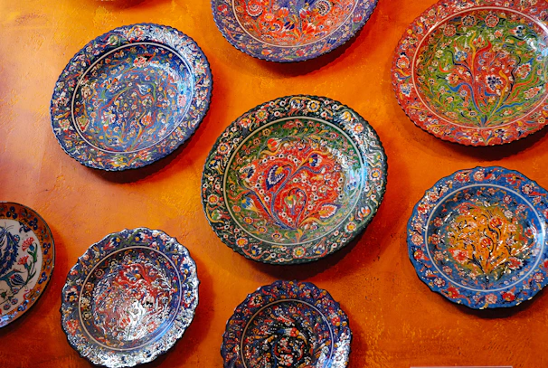 Close-up of a hand-painted ceramic plate with warm reds and yellows.