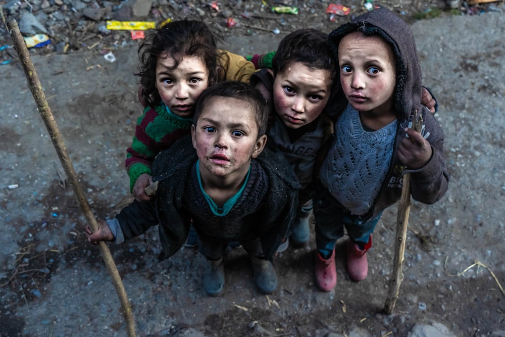 quatre enfants tenant des bâtons