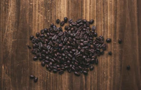 Close-up of handpicked Korean coffee beans resting on a rustic wooden table.