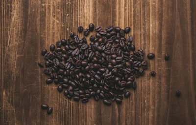 Close-up of handpicked Korean coffee beans resting on a rustic wooden table.