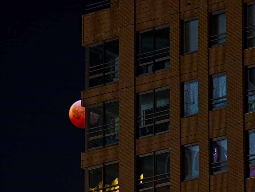 茶色のコンクリートの建物と地球のブラッドムーンの眺め