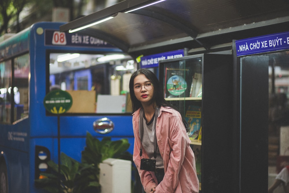 selective focus photography of woman standing under shed