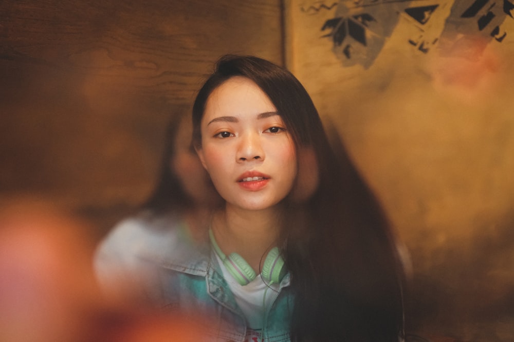 woman in blue denim jacket near brown wooden wall