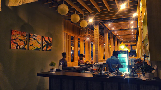 A cozy restaurant bar interior with modern point of sale terminals and ambient lighting.