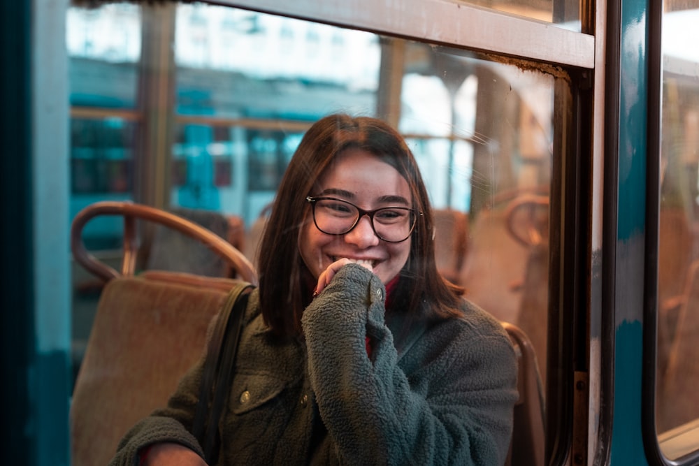 woman smiling while putting her hand on lips