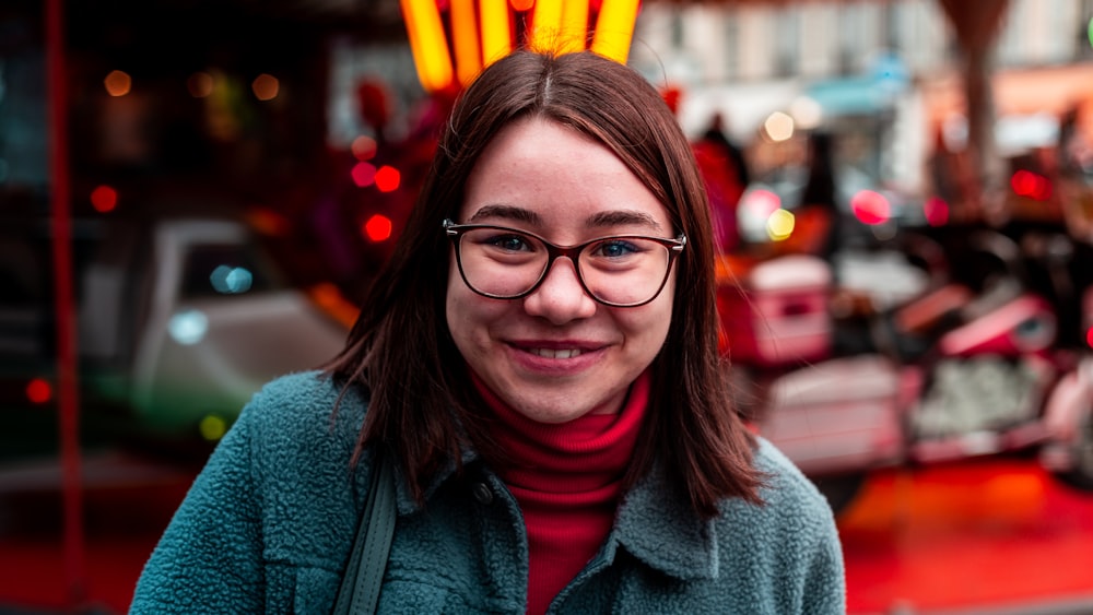 smiling woman wearing eyeglasses and green jacket