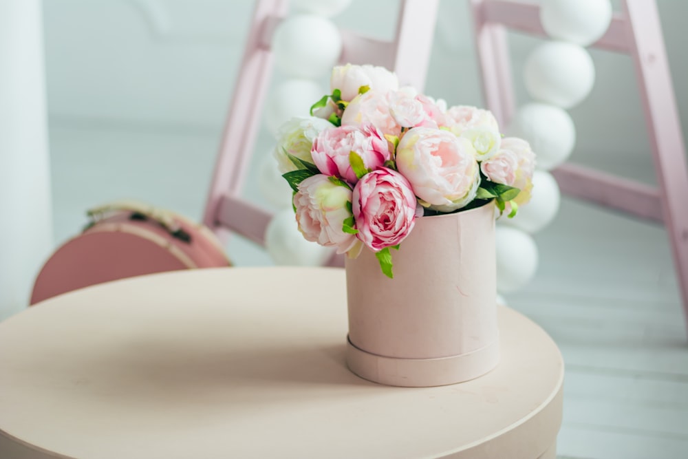 pink flowers in white vase on round table