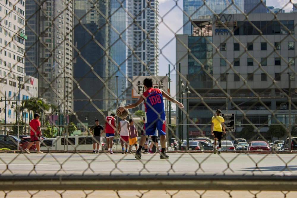 boys playing basketball on outdoor court during daytime