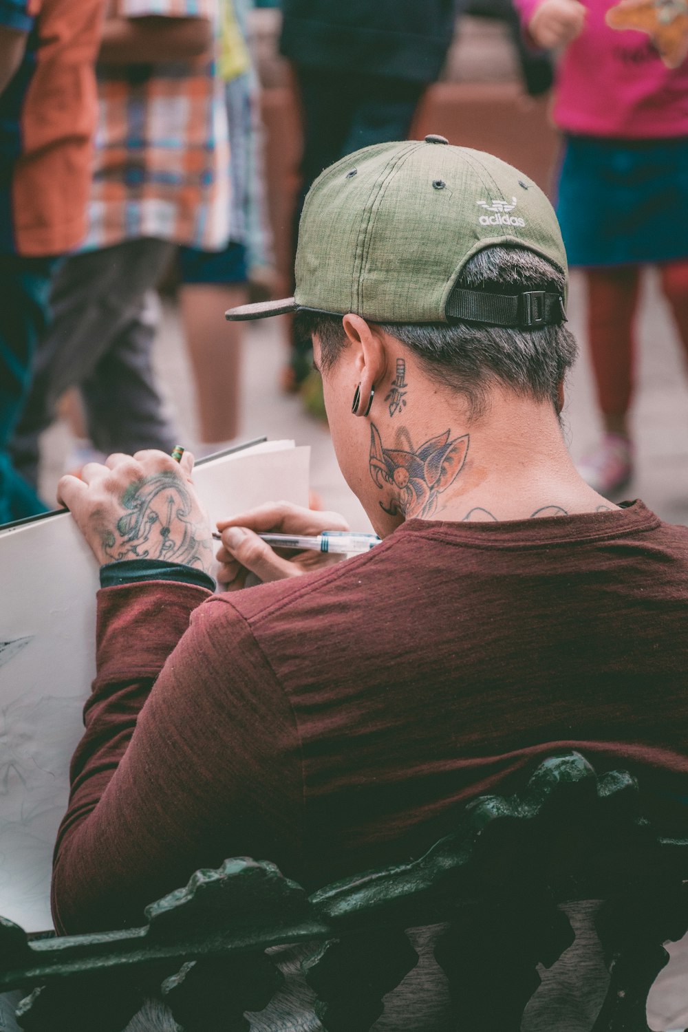 man sitting on bench while writing