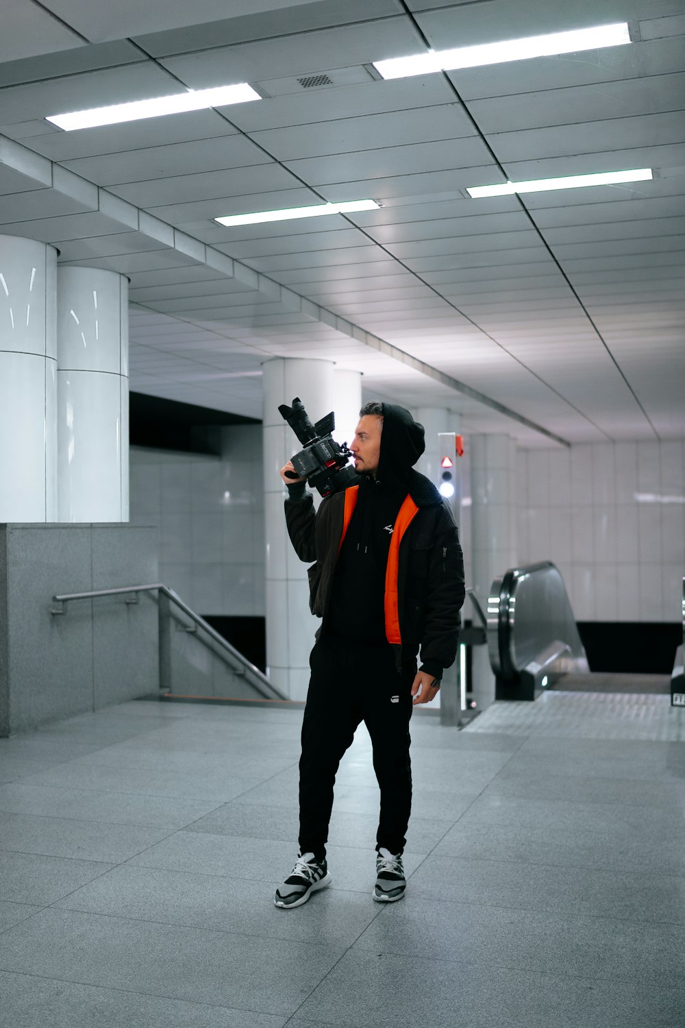 man wearing red and black jacket holding camera