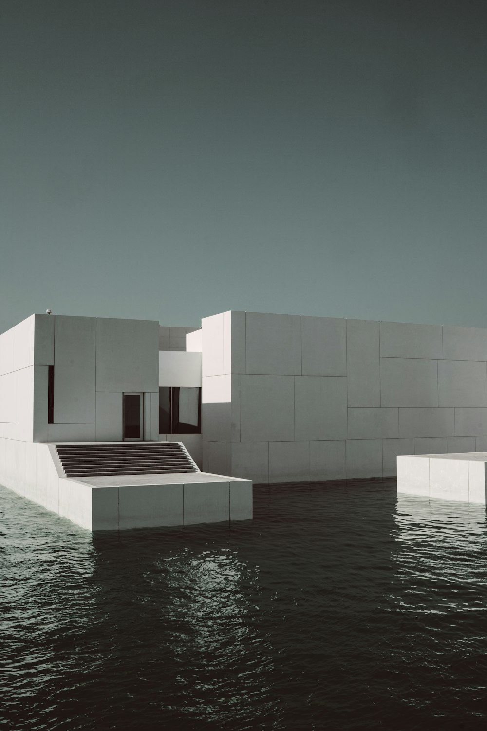 white building surrounded by body of water