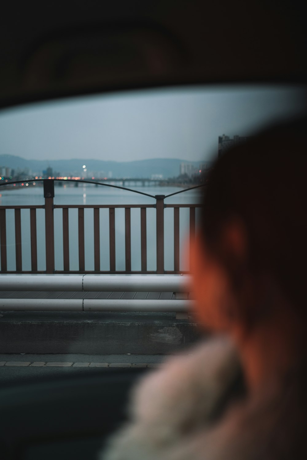 Selektive Fokusfotografie einer Frau im Auto, die auf der Straße in der Nähe des Geländers läuft