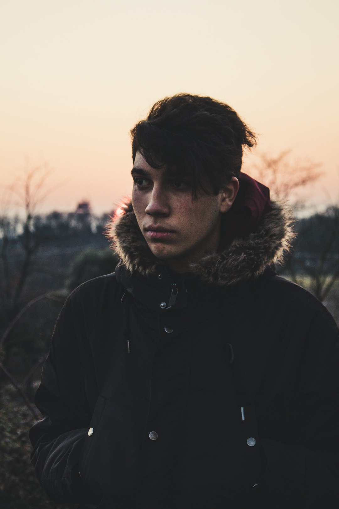 man wearing black coat standing outdoors