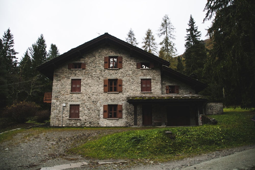 facade of grey brick house beside trees