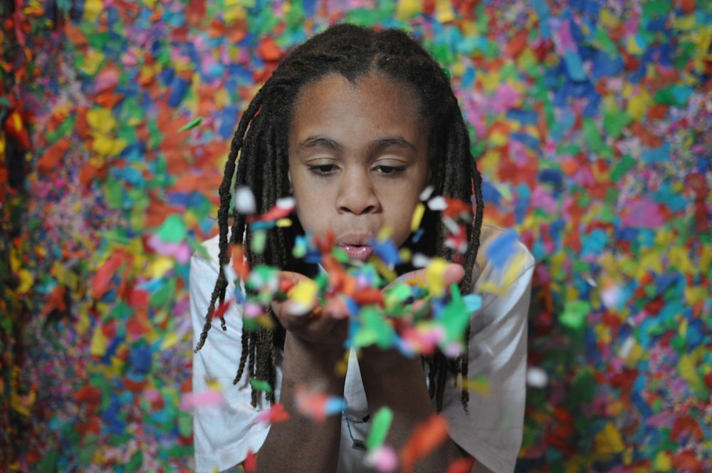 girl blowing confetti on hand