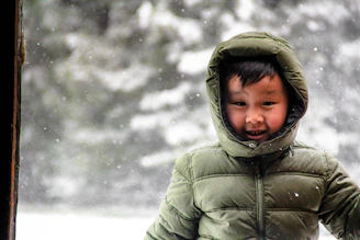 A smiling child in a warm jacket and hat set, perfect for chilly days.