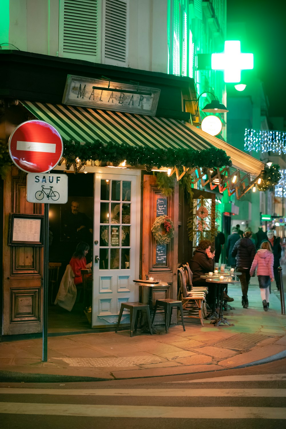 people walking beside buildings during nighttime