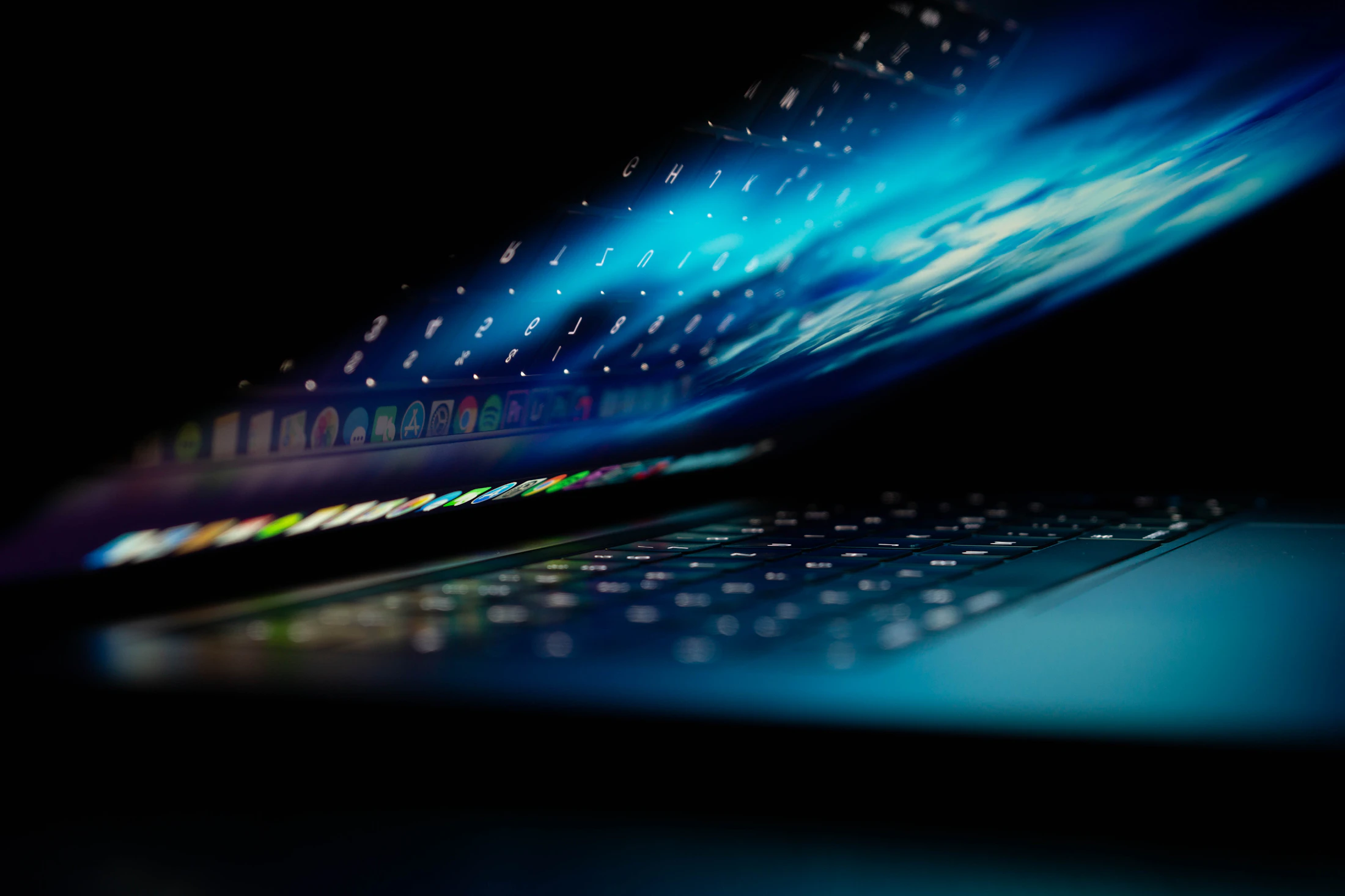 A laptop screen glowing blue in a dark room