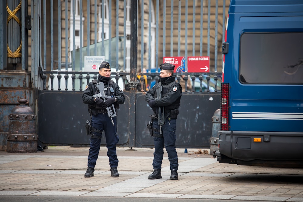 man holding black assault rifle standing on street