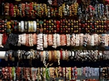 A vibrant display of colorful beaded bracelets laid out on a wooden table.