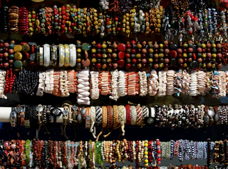 Array of silver bracelets adorned with colorful stones displayed on a linen cloth