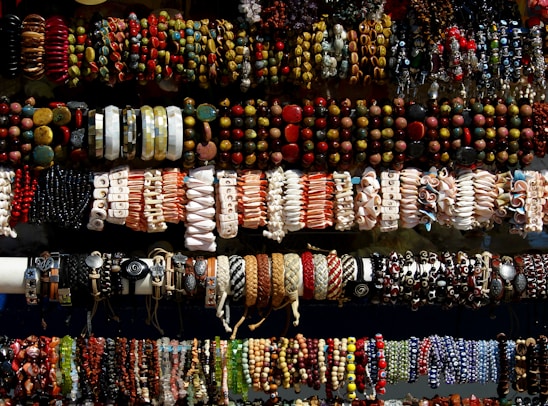 A collection of colorful paracord bracelets and accessories displayed on a rustic wooden surface.
