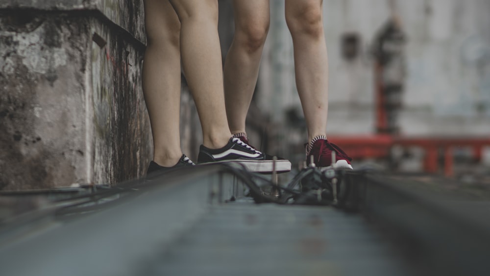 shallow focus photography of person wearing black Vans Old Skool