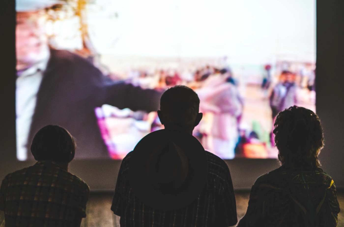 Three people watching TV together in the dark