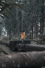 man standing on black metal staircase surrounded by trees