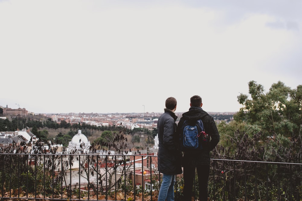 homme et femme debout à côté d’arbres verts