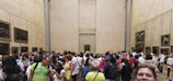 A bright, spacious white gallery filled with diverse visitors intently viewing vibrant queer artworks on the walls.