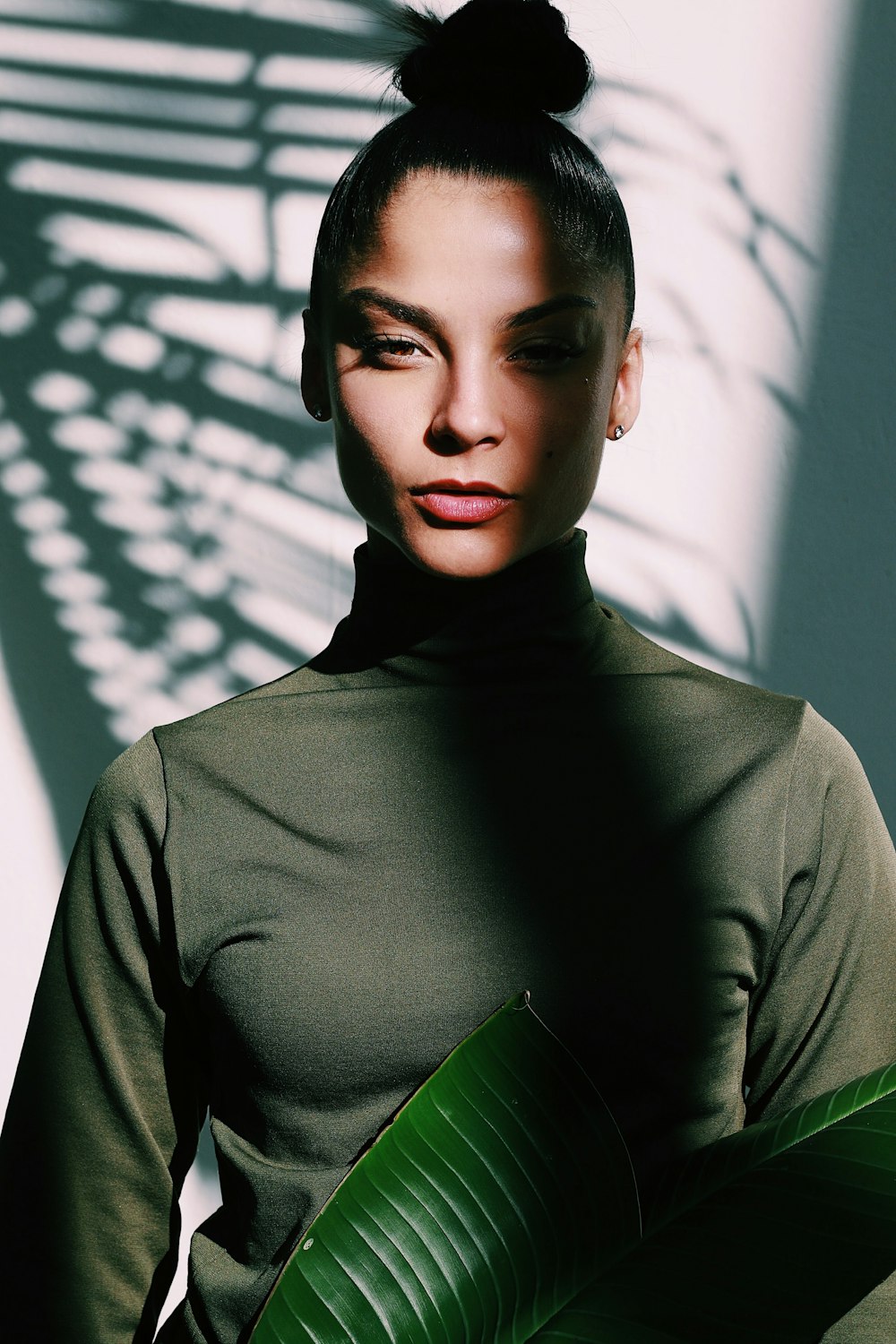 a woman standing in front of a shadow of a plant