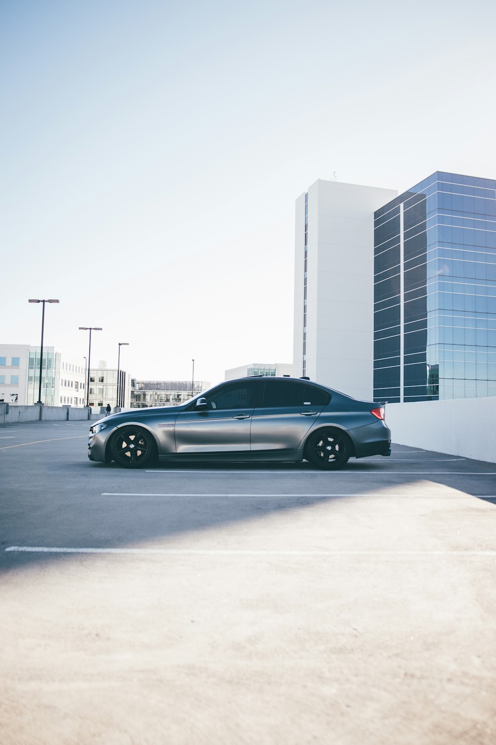 gray coupe parked near white building