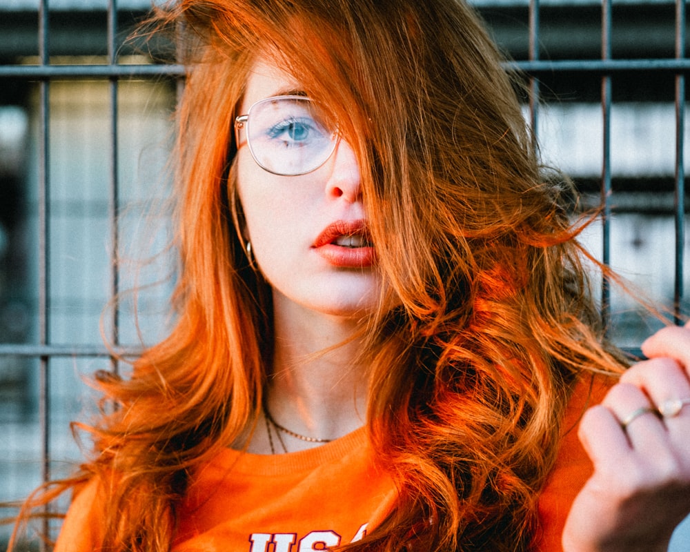 selective focus photo of woman wearing eyeglasses with orange hair