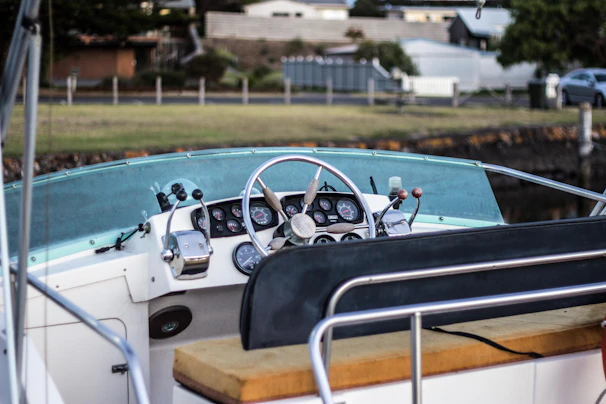 A close-up of hands steering the boat’s wheel, with the Saint Petersburg skyline softly blurred in the background.