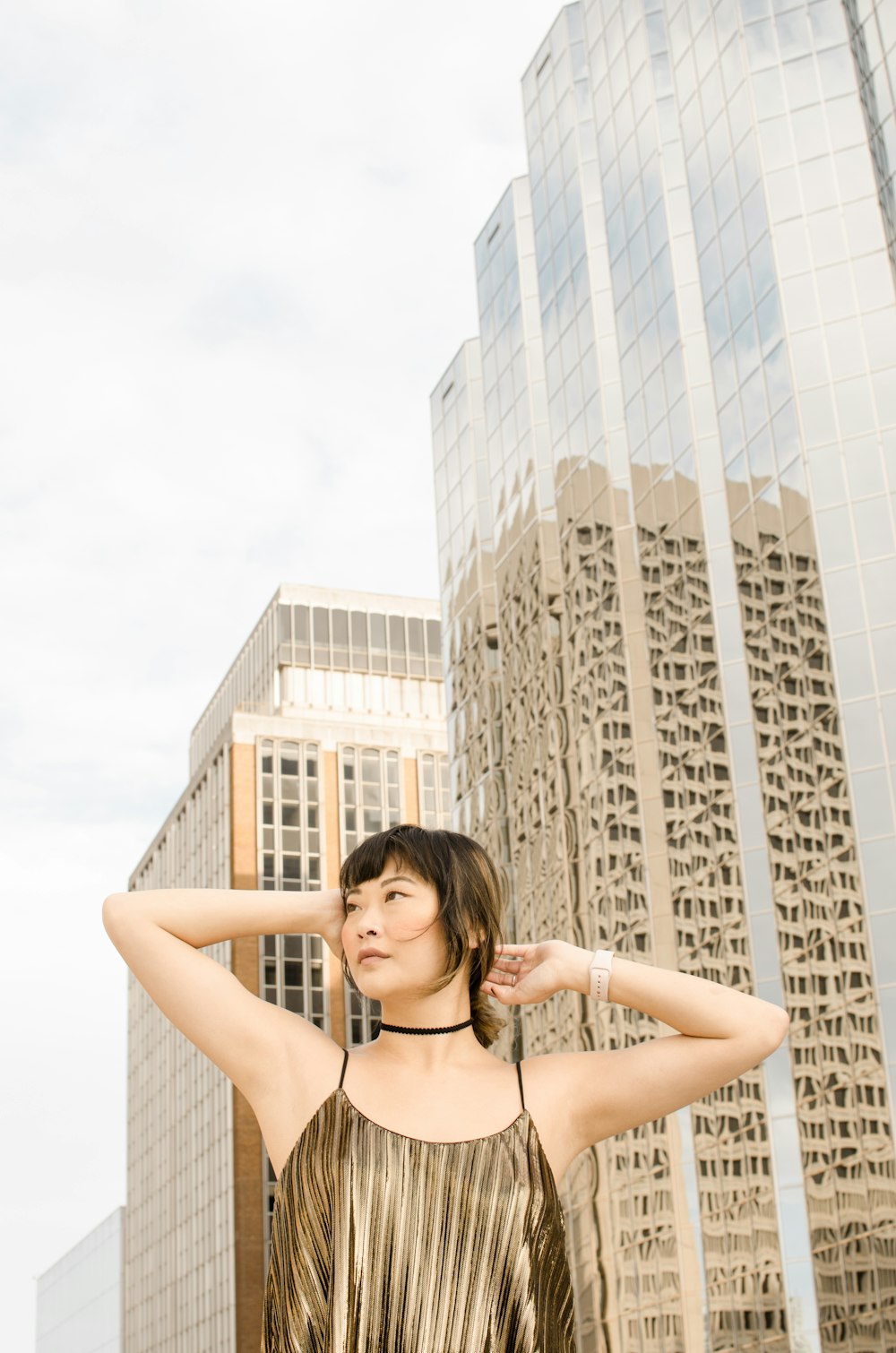 woman wearing brown spaghetti-strap blouse near building