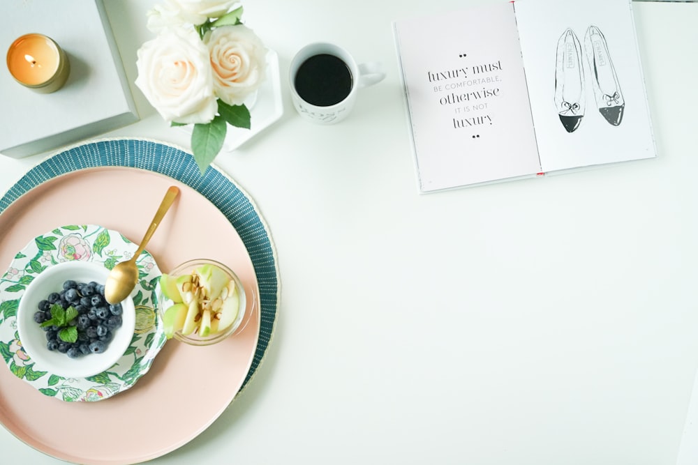 round pink plate with bowl and blueberries