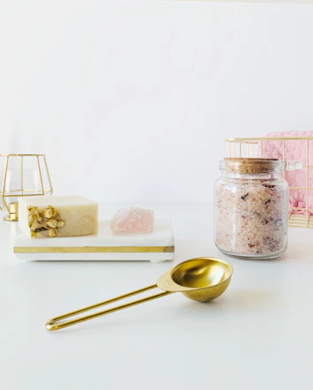 A beautifully arranged gift box featuring scented soaps, bath salts, and candles with soft natural lighting.