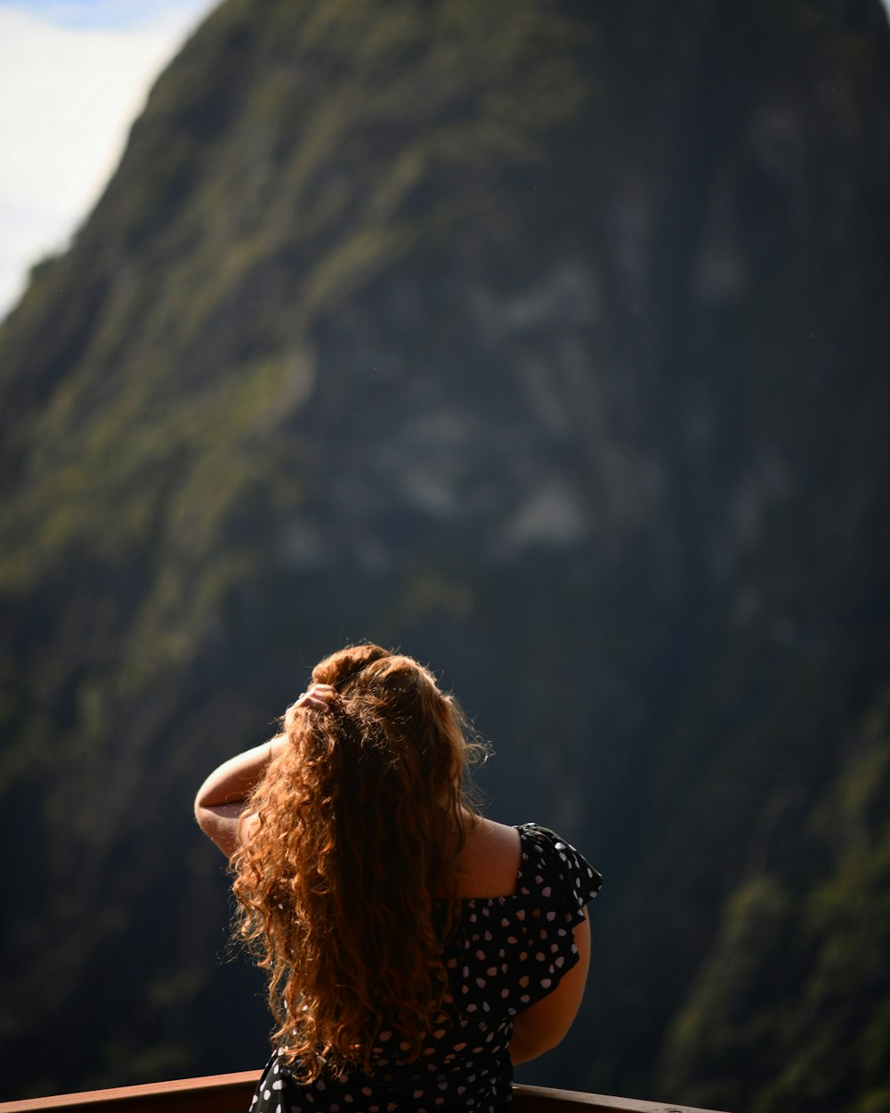 woman with curly hair and black dress at rail