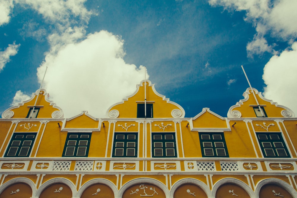 a yellow building with a clock on the front of it