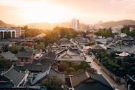 A scenic view of a Korean traditional village with cherry blossoms.