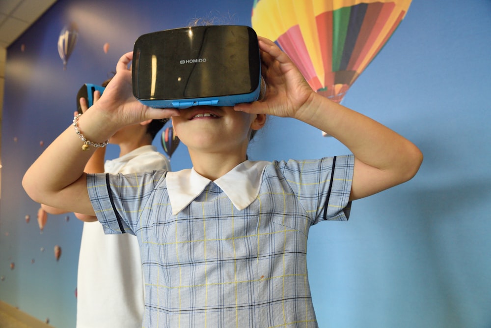 boys using blue and black virtual reality headset
