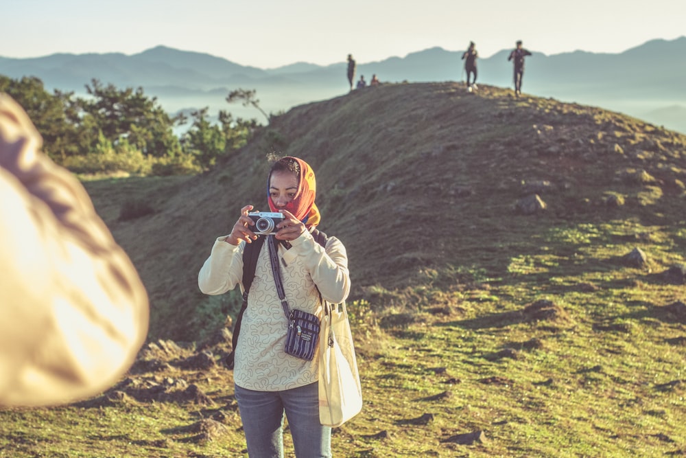 woman standing while using camera